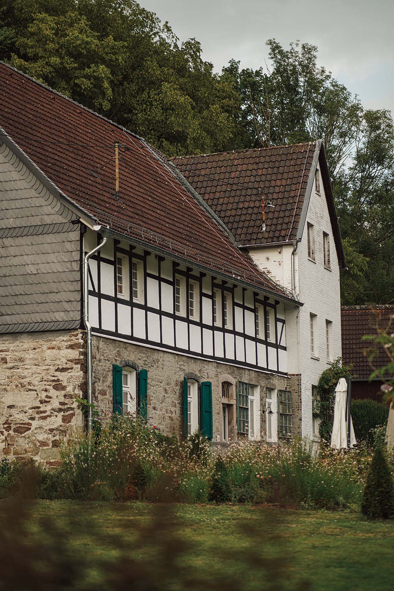 Historisches Mühlenhaus der Dürscheider Mühle mit Fachwerk, Naturstein und grünen Fensterläden